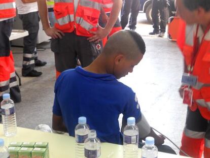 Uno de los menores es asistido por sanitarios de la Cruz Roja.