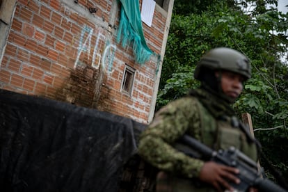 Un militar hace presencia para garantizar la seguridad de los habitantes al frente de un grafiti del grupo AGC.