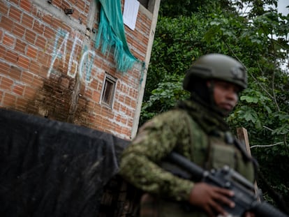 Un militar patrulla una calle en el Bajo Calima (Valle del Cauca), frente a un mural de las Autodefensas Gaitanistas de Colombia, el 15 de junio de 2024.