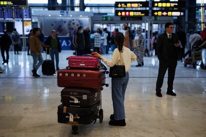 Una viajera con maletas espera para embarcar en el aeropuerto Adolfo Suárez Madrid-Barajas.