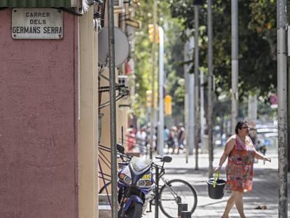 Una veïna neteja el carrer Germans Serra, en honor dels pintors del segle XIV Pere i Jaume Serra.