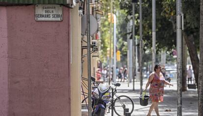 Una veïna neteja el carrer Germans Serra, en honor dels pintors del segle XIV Pere i Jaume Serra.