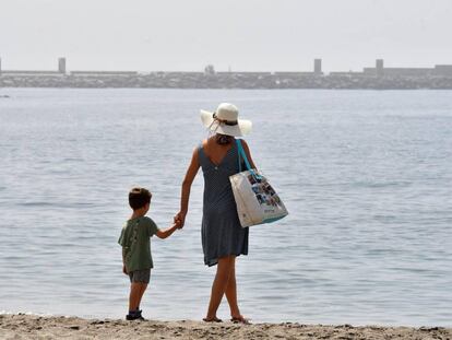 Una mujer y un niño pasean por la playa de El Zapillo en Almería. 