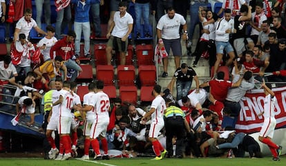 Aficionados del Sevilla caen al césped tras ceder una valla en Ipurúa este sábado.