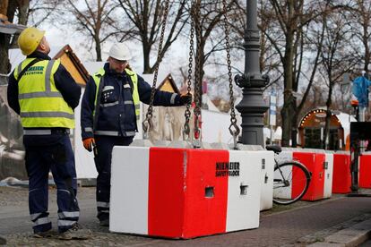 Trabajadores instalan barreras de seguridad en Schloss Charlottenburg, en los alrededores del mercado navideño en Berlín.
