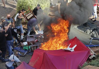 Algunos partidarios de Hezbollah queman tiendas de campaña en el campamento de protesta establecido por manifestantes antigubernamentales cerca del palacio de gobierno, en Beirut.
