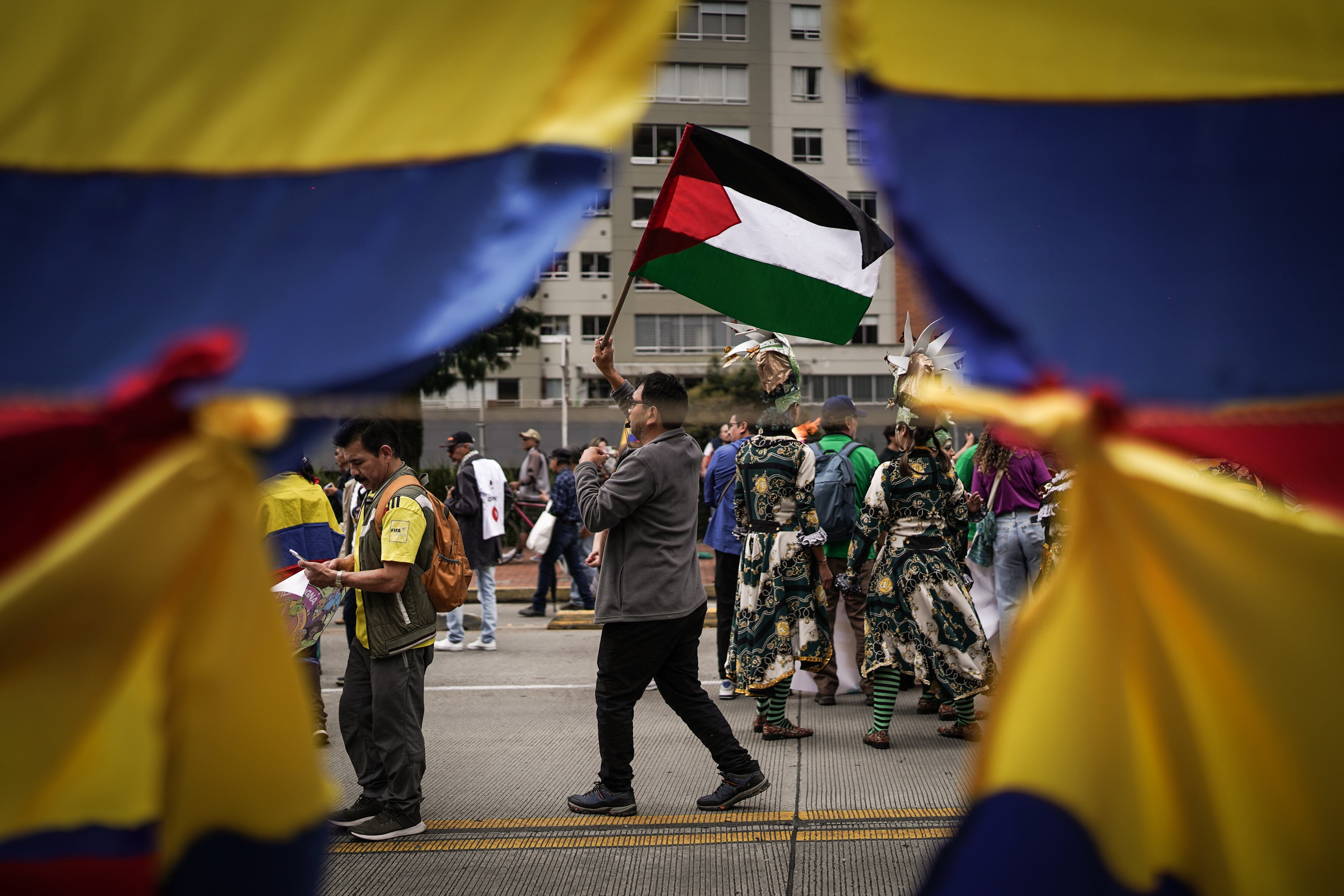 Un hombre lleva la bandera palestina en la marcha del 1 de mayo.