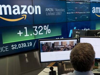 Un empleado del Nasdaq trabaja delante de unos monitores con el logotipo de Amazon.