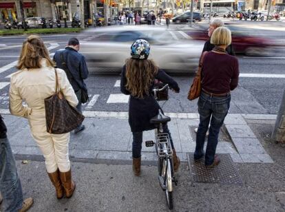Una ciclista espera a que el semáforo se ponga en verde.