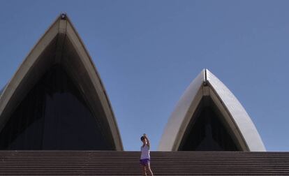 Una mujer se hace una foto en las escaleras de acceso al edificio de la ópera de Sidney.