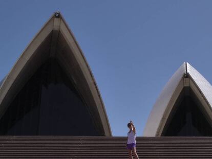 Una mujer se hace una foto en las escaleras de acceso al edificio de la ópera de Sidney.