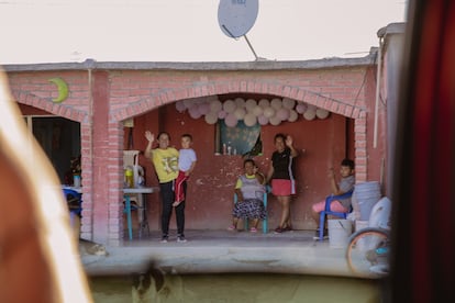 Sanjuana y su familia saludan desde el porche de su casa en Charco Cercado.