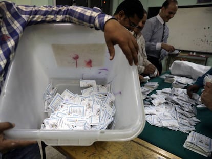 Un hombre lleva una urna con votos para el recuento en Egipto.