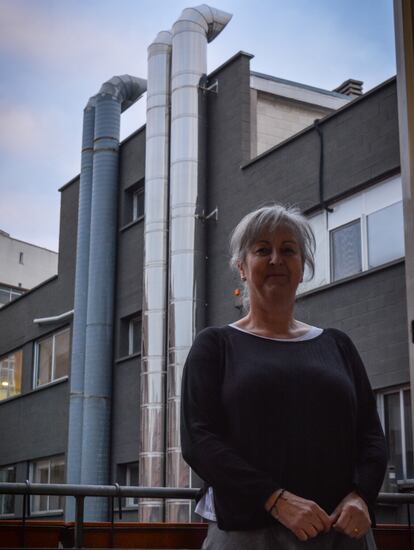 Esther Lomas, en al balcón de su habitación, donde se aprecian las chimeneas de una cocina industrial en el distrito de Arganzuela.