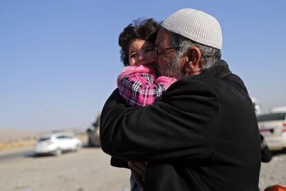 Un hombre iraquí abraza a su nieta tras haber sido reunido con su familia, en Bartella (Irak).