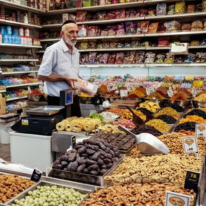 An Israeli man sells groceries at the Mahane Yehuda market in Jerusalem, on August 25, 2022. (Photo by RONALDO SCHEMIDT / AFP) (Photo by RONALDO SCHEMIDT/AFP via Getty Images)