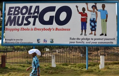 Un hombre pasa ante un cartel del Gobierno de Monrovia contra el &eacute;bola.