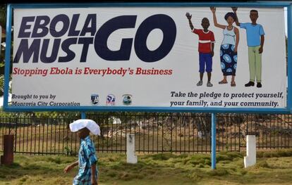 Un home passa davant un cartell del Govern de Monròvia contra l'ebola.