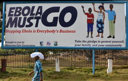 Un hombre pasa ante un cartel del Gobierno de Monrovia contra el ébola.