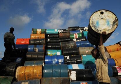 Un hombre apila barriles de petróleo vacíos en un depósito de Santo Domingo (República Dominicana). Un grupo de residentes haitianos venden los bidones por nueve dólares (unos ocho euros), el 6 de febrero