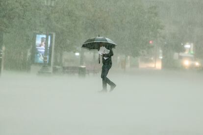 Un hombre camina bajo una intensa lluvia este viernes en Valencia.