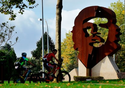 Dos ciclistas pasan por delante del monumento dedicado al Che Guevara en el municipio de Oleiros (A Coruña).