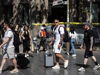 Turistas con maletas en Las Ramblas de Barcelona.