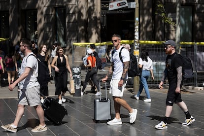 Turistas con maletas en Las Ramblas de Barcelona.