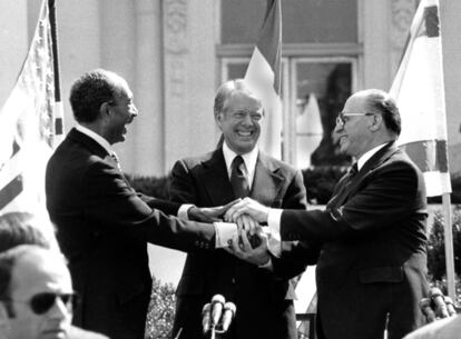 El presidente egipcio Anwar Sadat (izqda.), el presidente de Estados Unidos Jimmy Carter (centro) y el primer ministro israelí Menachem Begin se dan la mano en el jardín norte de la Casa Blanca tras la firma del tratado de paz entre Egipto e Israel, en marzo de 1979 . Sadat y Begin fueron galardonados con el Premio Nobel de la Paz en 1978. Carter debió esperar hasta 2002 para recibir el galardón.