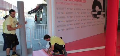 Varios operarios dan ayer los últimos retoques a la alfombra roja por la que desfilarán las estrellas a su entrada en el Kursaal.