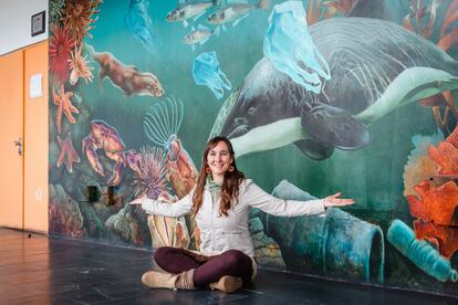 La bióloga Carla Christie frente a un mural que incluye al delfín chileno, entre otras especies marinas del país austral.