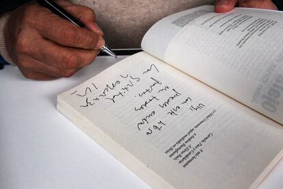 El escritor Juan Cruz dedica uno de sus libros en la Feria del Libro de Madrid.