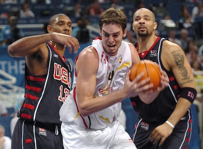 El jugador español Pau Gasol (centro) lucha bajo el aro con los estadounidenses Timothy Duncan (izquierda) y Carlos Boozer, durante el partido de cuartos de final del torneo de baloncesto de los Juegos Olímpicos de Atenas 2004, en agosto. España perdió por 94 a 102.