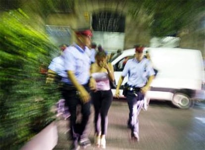 Una prostituta entre dos  Mossos d? Esquadra, ayer, en Barcelona.