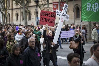 Una manifestación sujeta una cruz y varios carteles durante la marcha en Barcelona.