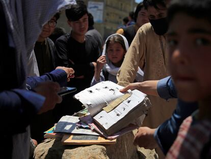 Un grupo de afganos recupera los libros de una escuela situada cerca del lugar de un bombardeo en Kabul, el 9 de mayo de 2021.