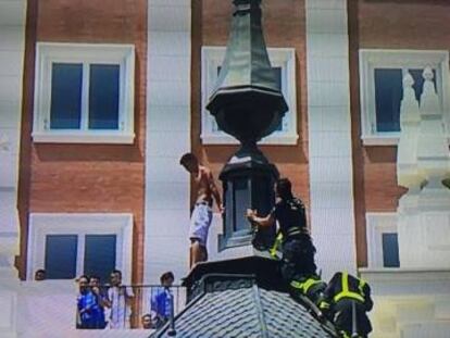 Bomberos acercándose al hombre que amenazaba con lanzarse a la Gran Vía.