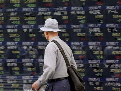 Un hombre pasea por un panel de cotizaciones en Tokio