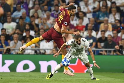 El defensa de la Roma Federico Fazio lucha con el delantero del Real Madrid Karim Benzema por hacerse con la posesión del balón.