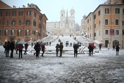 Los bellos monumentos de la capital se han cubierto totalmente de blanco. Turistas en la plaza de España en Roma tras la fuerte nevada, el 26 de febrero de 2018.