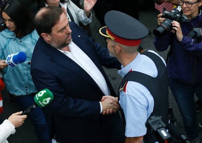 El vicepresidente de la Generalitat, Oriol Junqueras, saluda a un Mosso a su llegada escuela Sant Jordi de Barcelona.