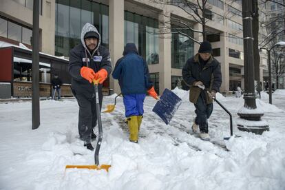 Workers clear snow from the sidewalk on Pennsylvania Avenue February 17, 2015 in Washington, DC. The DC area received several inches of snow effecting public transportation and shutting down the Federal Government. AFP PHOTO/Brendan SMIALOWSKI