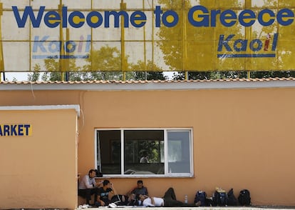 Un grupo de sirios descansa en una gasolinera desierta en el norte de Grecia.