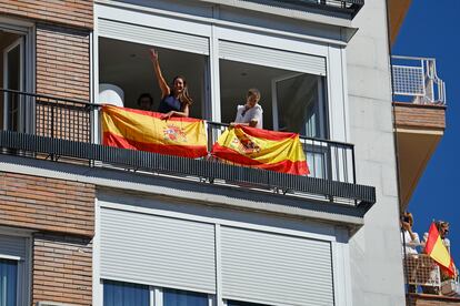 Vecinos miran por los balcones durante el acto del PP celebrado en Madrid, este domingo. 