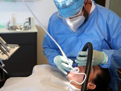 Un dentista atiende a una paciente.