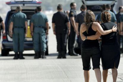 Familiares de los españoles asesinados en Afganistán acompañan a los féretros a su llegada ayer a la base de Torrejón de Ardoz.