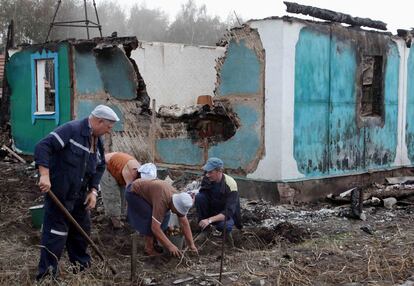 Un grupo de personas recupera patatas y otro tubérculos de su huerto, totalmente arrasado por el fuego, en Voronezh.