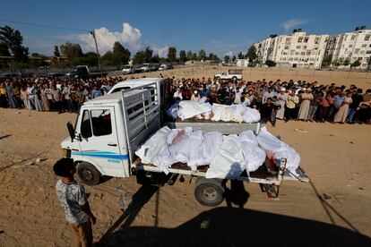 Dos camionetas trasladaban decenas de cadáveres de víctimas palestinas antes de que fueran enterradas en la localidad de Jan Yunis, este miércoles. 