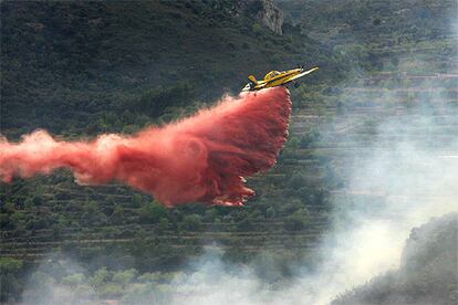 Una avioneta, durante los trabajos de extinción del fuego declarado ayer en Atzeneta del Maestrat.