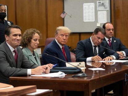 El expresidente Donald Trump, rodeado de sus abogados y escoltado por alguaciles, en el tribunal de Nueva York donde se han leído los cargos contra él.